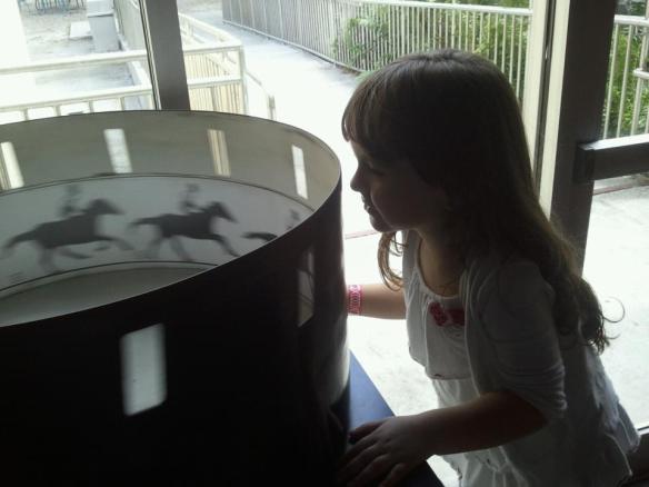 Madison looking into a zoetrope.